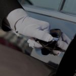 Χέρι με λευκό γάντι ανοίγει την πόρτα ενός αυτοκινήτου.